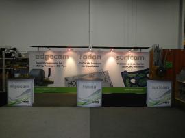 RENTAL:  RE-2028 Includes Back Wall Structure with (2) Flat Canopies, SEG Tension Fabric Graphic, (5) Halogen Arm Lights, and (3) RE-1228 Small Curved Counters with Interior Shelves and Locking Doors -- Image 1