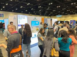 RENTAL: Modified RE-2107 Gravitee Panel System Inline Design with Gravitee Lightbox Panel, RE-1586 Backlit Reception Counter, Monitor Mount, 50” Monitor, White Laminated Shelf, and SEG Fabric Graphics -- View 3