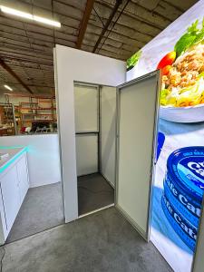 RENTAL: Custom 10' x 25' Inline Design with Gravitee System Storage Closet, Curved Gravitee System Panels, (3) Single-Sided Lightboxes, Left Side Half Wall, Bump-Out Panels, RE-1576 White Laminated Reception Counter, RE-1577 White Laminated Reception Coun