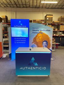 RENTAL: Modified RE-1090 Inline Design with SYM-502 Large Arch SEG Frame, 42" Wide x 95" High Single-Sided Lightbox, RE-1576 White Laminated Reception Counter, LED Arm Light, 43" Monitor, SEG Fabric Graphics, and Vinyl Applied Graphics