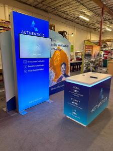 RENTAL: Modified RE-1090 Inline Design with SYM-502 Large Arch SEG Frame, 42" Wide x 95" High Single-Sided Lightbox, RE-1576 White Laminated Reception Counter, LED Arm Light, 43" Monitor, SEG Fabric Graphics, and Vinyl Applied Graphics -- View 2