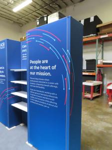 GK-1014 Gravitee Modular Inline Exhibit with Backlit Fabric Graphics, Shelves, LED Stem Light, and GOD-1558 Counter with Locking Storage -- View 3