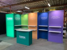 RENTAL: Modified RE-2094 Gravitee Inline Design with Storage Closet with Locking Door, RE-1558 Gravitee Reception Counter with White Laminated Top, (10) White Laminated Shelves, (2) LED Arm Lights, SEG Fabric Graphics