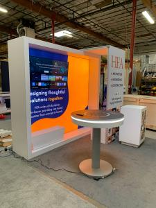 RENTAL: RE-1081 Design with White Laminated Backwall with Single-Sided Lightbox, Arch Canopy Structure, RE-704 Charging Station Table, Workstation Counter, Planter Box, Storage Box, Large Monitor Mount, 55" Monitor with HDMI Cable, SEG Backl
