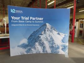 Modified SYK-2025 Symphony Portable Display with SEG Tension Fabric Graphics, Peak and Concave Frames, SYM-406 Portable Counter w/ Locking Storage, and LED Stem Lights