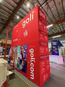 RENTAL: Custom Island Design with Dual Gravitee Storage Closet Structure @ 16 ft. High, with Two Locking Doors, Double-Sided Curved Gravitee Wall @ 12 ft. High for Meeting Area, (3) RE-1597 Curved White Laminated Counters, RE-702 Charging Station Table, (